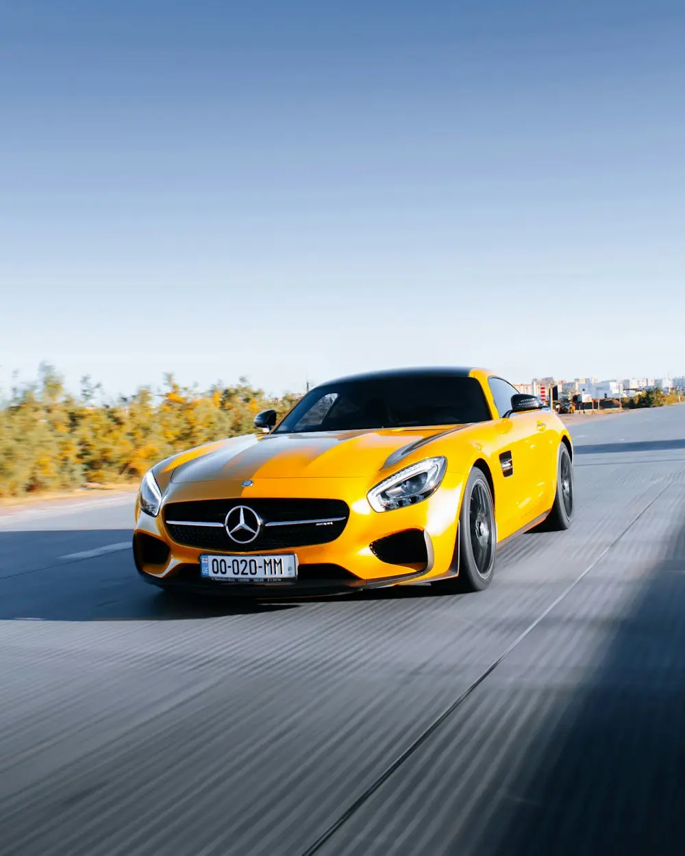 Yellow Mercedes-AMG GT with mirror-gloss paint on open road